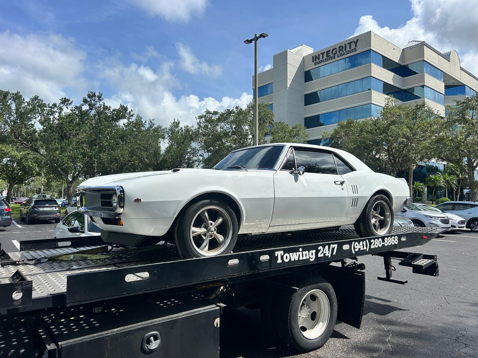 A classic Firebird secured on the flatbed